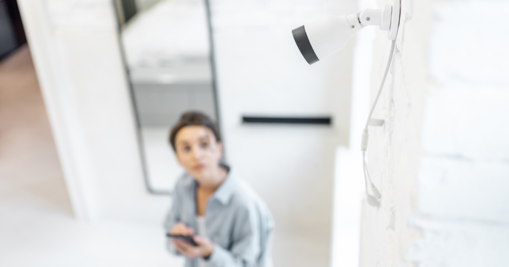 woman in a foyer looking up at a security camera