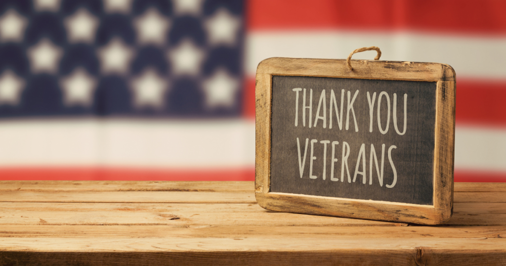 sign saying "thank you veterans" with a US flag in the background